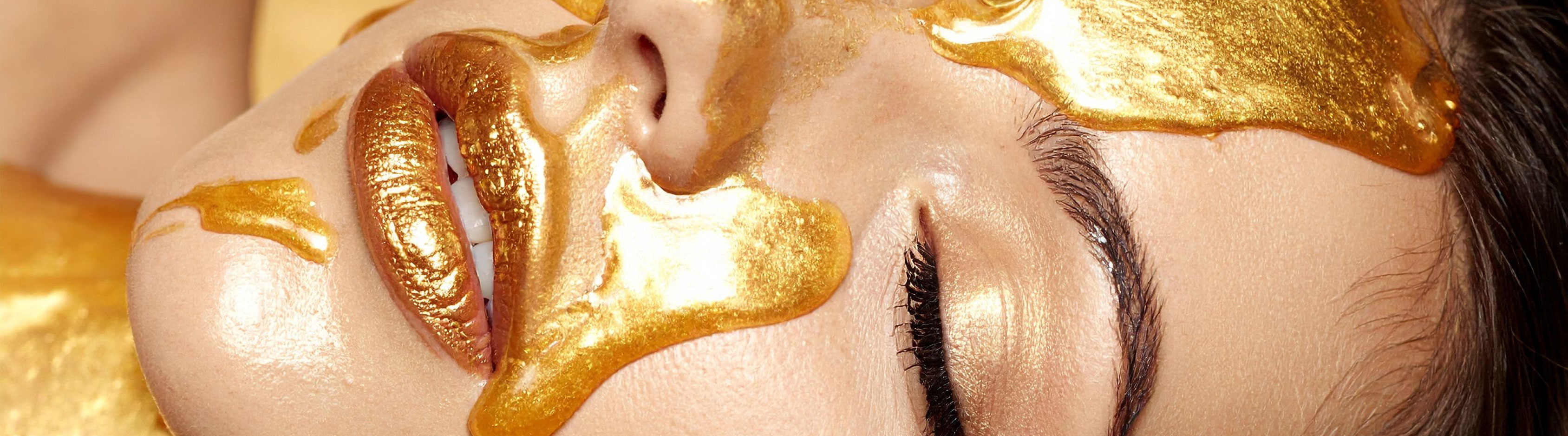 ženský obličej politý zlatou tekutinou