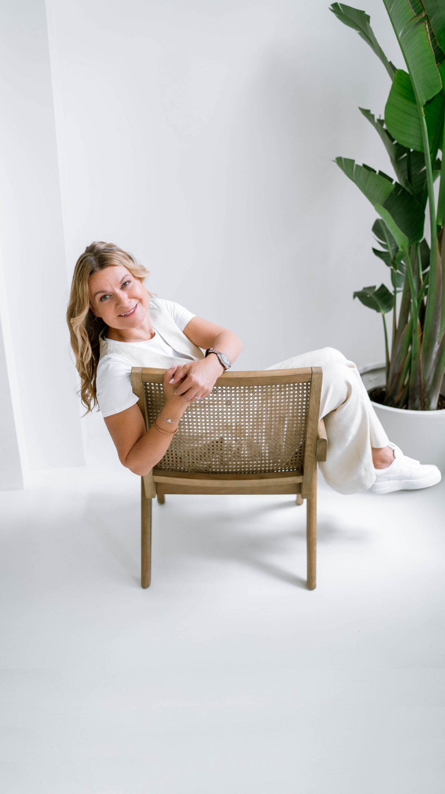 Petra Součková sedící na židli v bílé místnosti, v pozadí kytka