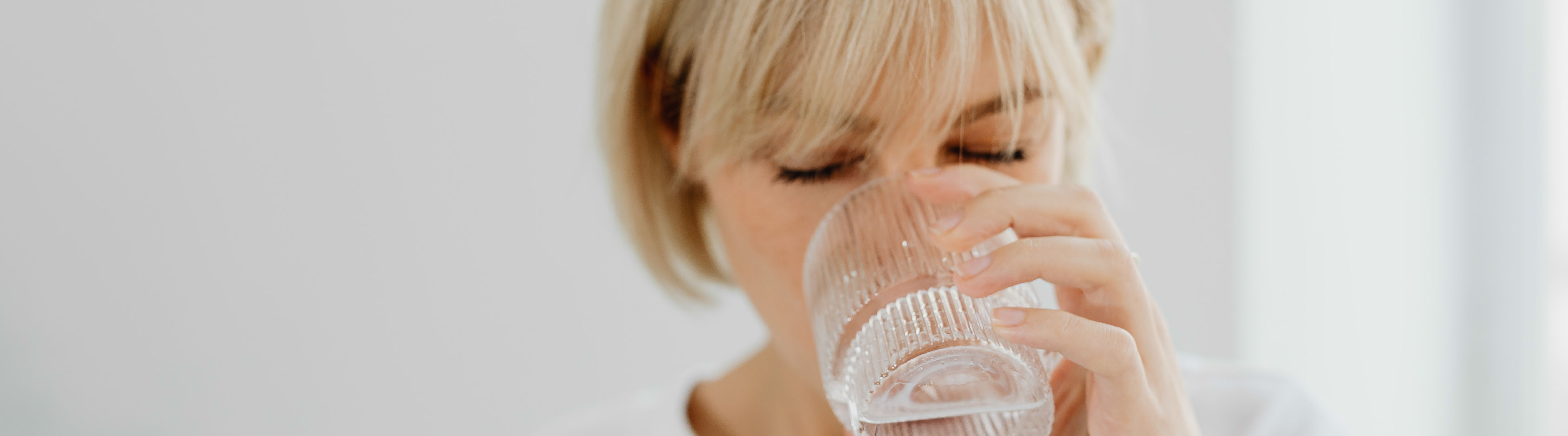 žena pije vodu ze sklenice